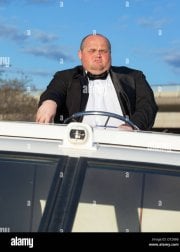 overweight-man-in-a-tuxedo-at-the-helm-of-a-pleasure-boat-closeup-D7286B.jpg