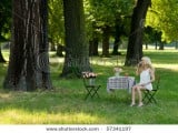 stock-photo-young-blond-in-the-park-under-trees-sitting-relaxed-on-a-folding-chair-beside-a-folding-