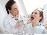 stock-photo-dentist-using-dental-filling-gun-on-woman-74865799.jpg