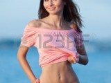 12152217-ragazza-al-mare-attraente-giovane-donna-mostrando-il-suo-sexy-pancia-sullo-sfondo-del-mare-