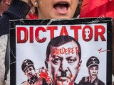 a-young-british-alevi-protester-holds-a-poster-showing-president-erdogan-KXEW01.jpg