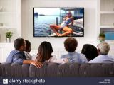 multi-generation-family-watching-tv-at-home-back-view-X9KHBE.jpg